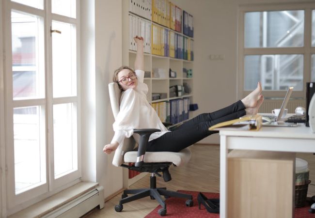 Kobieta pracuje w biurze z nogami na biurku